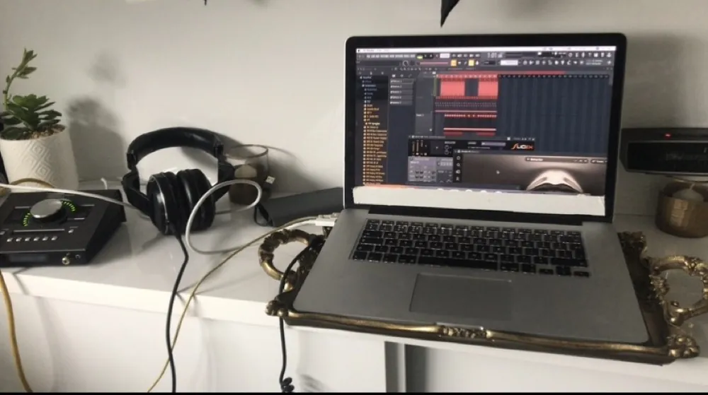 Mesa de estúdio com notebook, fones e interface de áudio